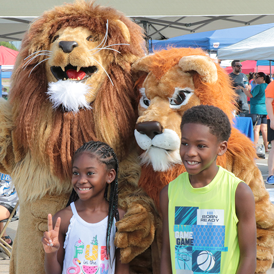  Children pose with two lion mascots